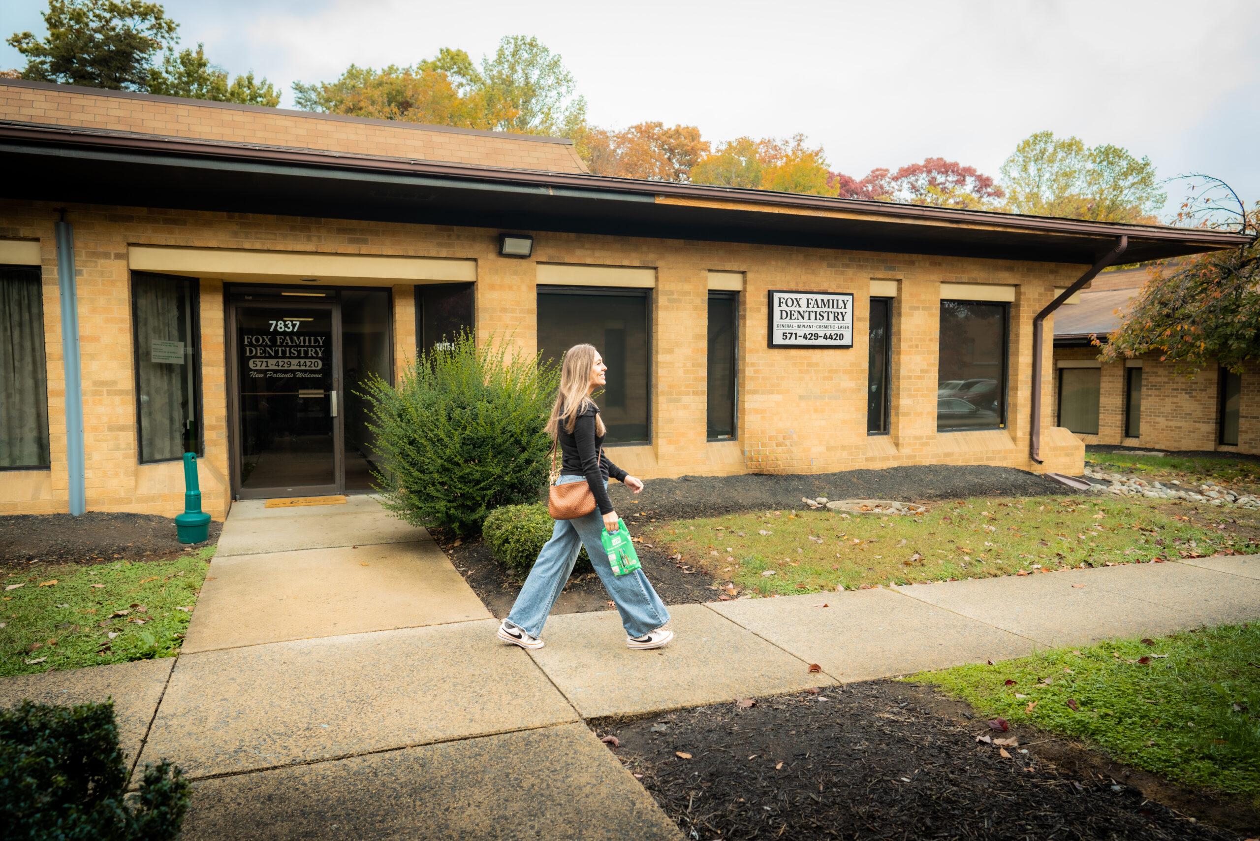 Fox Family Dentistry Walking Woman Outside Woman walking past Fox Family Dentistry clinic in Springfield and Burke, VA